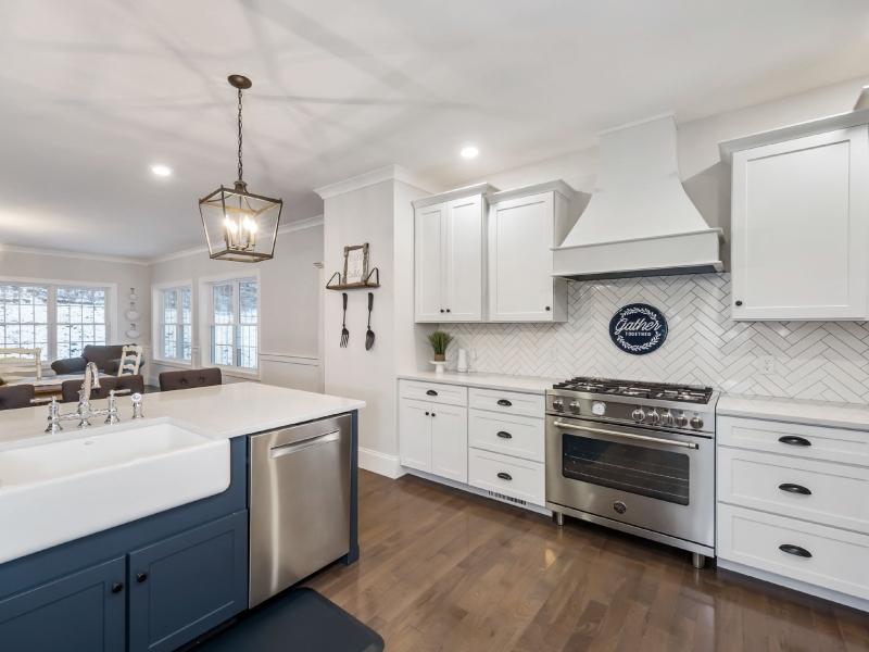 Kitchen with white cabinets, stainless steel appliances, and a blue island
