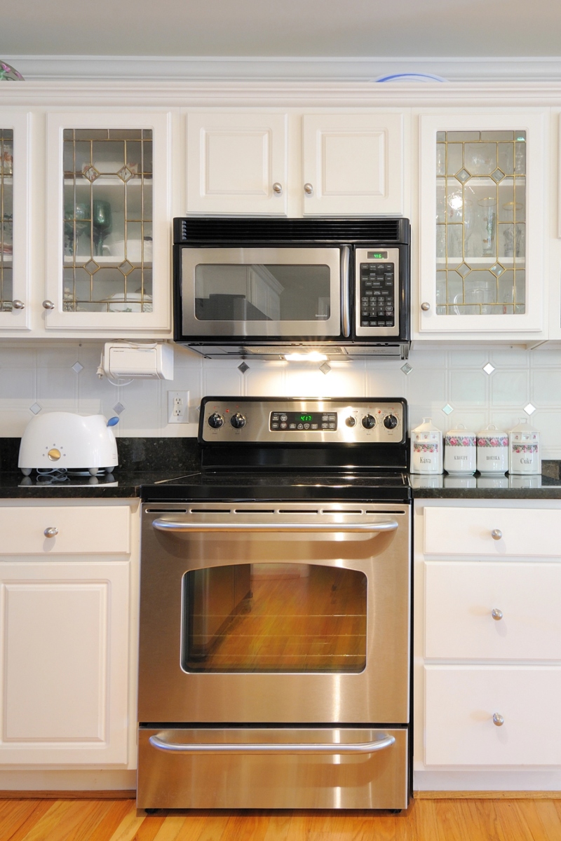 6 Kitchen with white cabinets, stainless steel appliances, and a black stovetop