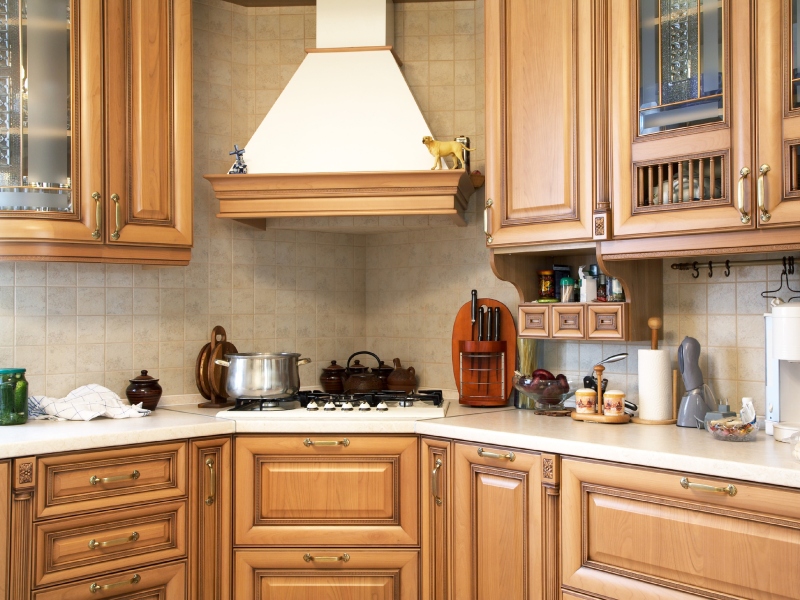7 Cozy kitchen with wooden cabinets, a white range hood, a tiled backsplash, and various kitchen utensils and decorations